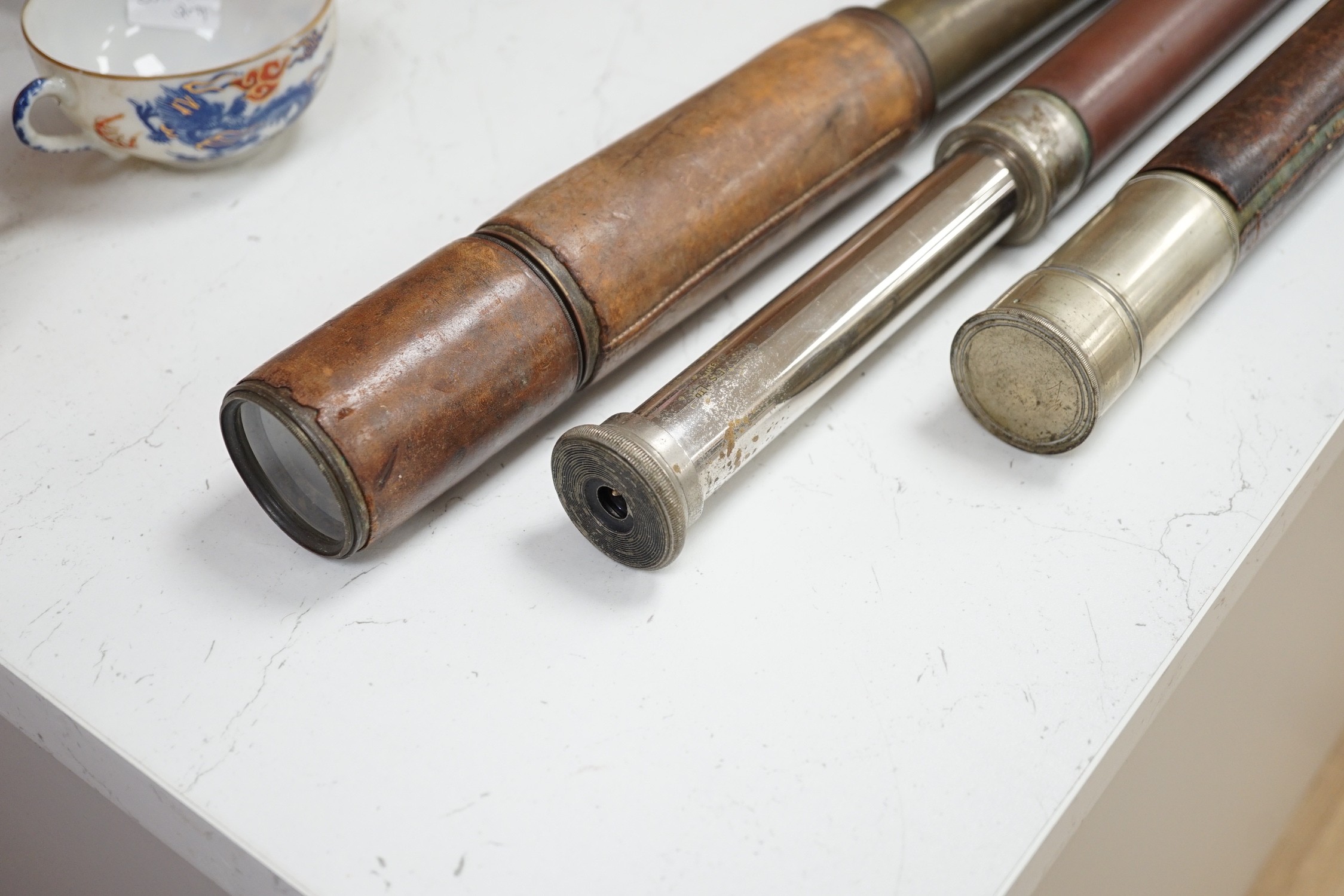 Three leather bound telescopes